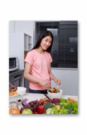 woman mixing salad while cooking in kitchen