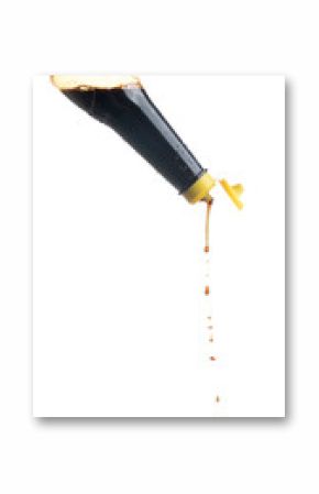 Pouring soy sauce from a bottle on white background