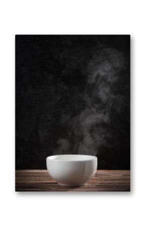 Steam of hot soup with smoke in ceramic bowl against black cement wall