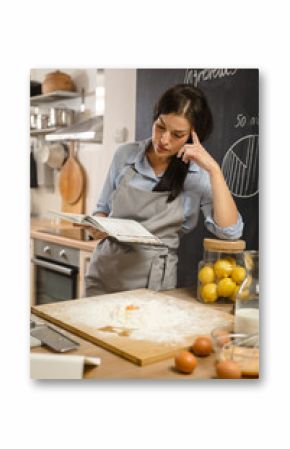 checking recipe in cookbook. Woman preparing american pie