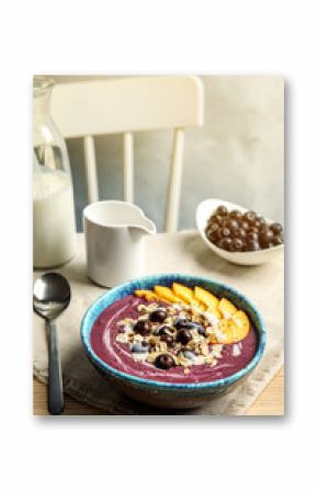 Bowl with tasty acai smoothie on wooden table