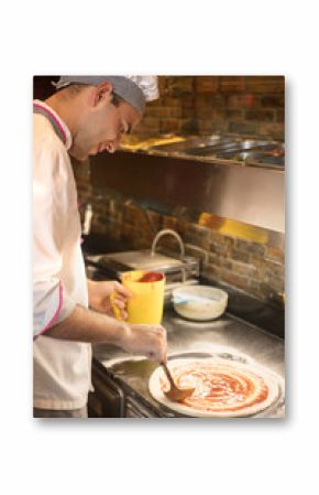 chef baker in white uniform making pizza at kitchen