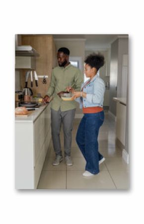 Couple cooking together in modern kitchen, preparing meal with fresh ingredients