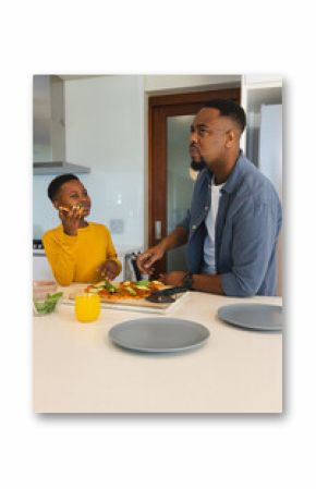 Preparing healthy breakfast together, African American father and son in modern kitchen