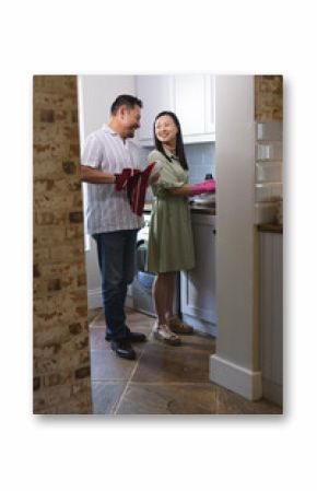 Mature couple in kitchen, smiling while preparing meal together, enjoying cooking