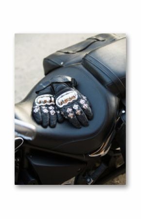 gloves with metal elements on leather seat of chopper motorcycle