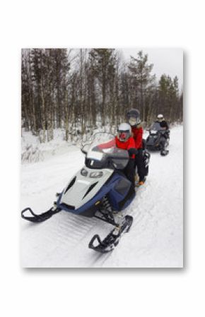 Family driving a snowmobile in Ruka of Lapland, Finland