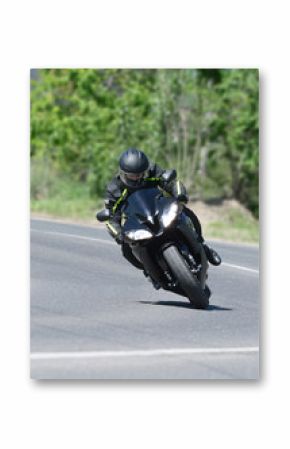 The biker on the black sports motorcycle on a bend on speed