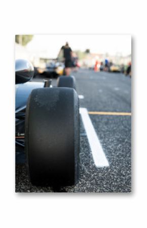 Black slick motor sport car tire close up