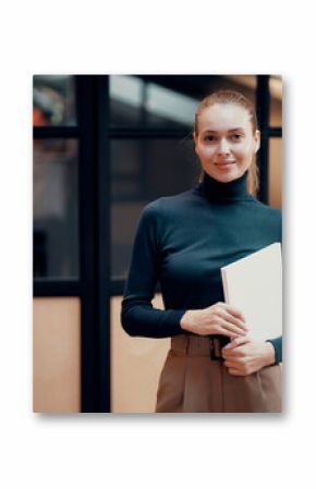 Portrait of a confident young woman European appearance brown-haired. Checks the documents in the folder. Office clothes, favorite coworking job. Blue eyes, looking away.