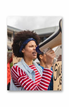 Mixed race woman using megaphone and holding placard at a protest march