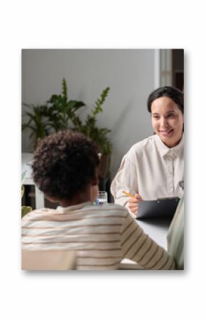 Portrait of smiling young woman talking to family in consultation over desk in office, copy space