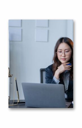 A female attorney is diligently working at her desk in the office.