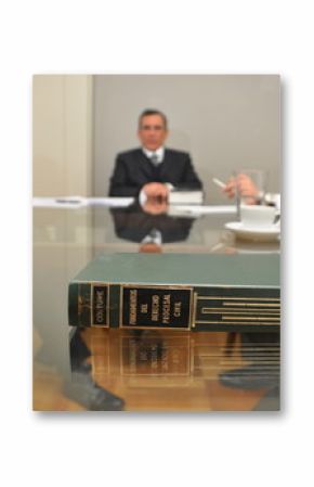 avvocati durante una riunione seduti ad un tavolo di vetro con un testo di legge