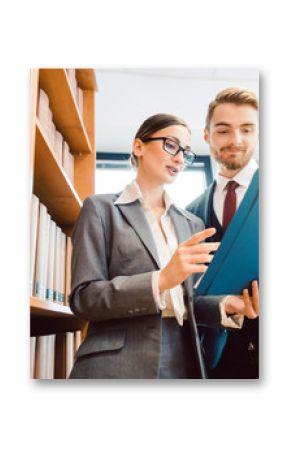 Lawyers in library of law firm discussing strategy in a case holding file