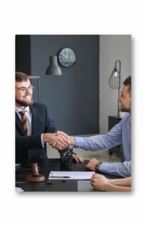 Male lawyer with client shaking hands in office