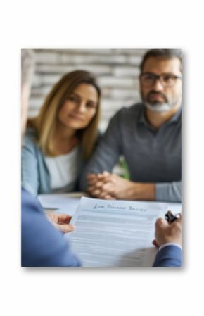 In an office setting, a lawyer clarifies a legal document to a couple, providing guidance and answering questions. The atmosphere is focused and professional, emphasizing clear communication