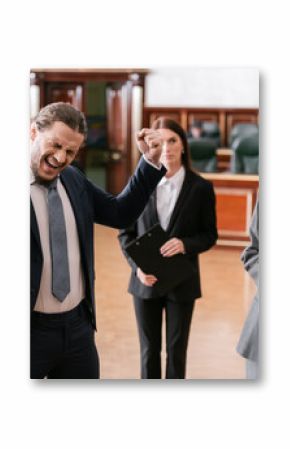 excited businessman shouting and showing win gesture near attorney in court