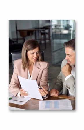 Female busy lawyer or financial advisor consulting older male client investor showing documents at meeting. Two mature business executive colleagues discussing account paperwork report in office.