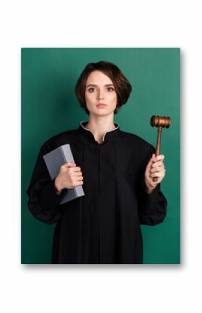 Photo of serious confident woman attorney judge holding book and gavel wear black robe isolated on green color background