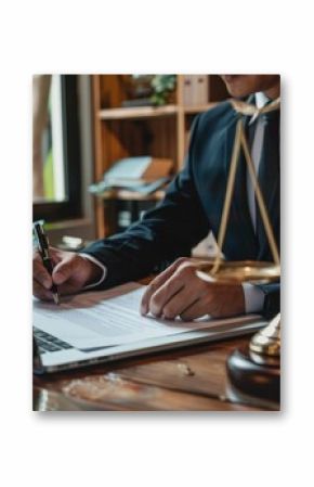 Businessman working on a legal document at the office desk with scales of justice and gavel, symbolizing law and legal profession.