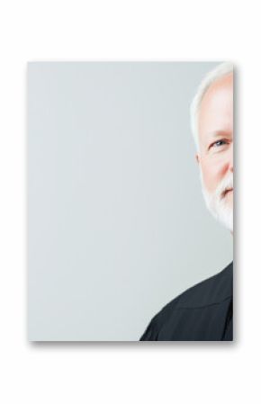 A close-up of a serious 50-year-old judge in a black robe, set against a white background, highlighting the judge’s expression of authority and focus. photo