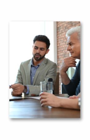 Male notary working with mature couple in office