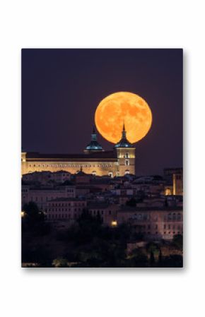 Wonderful scenery of illuminated ancient palace built over town in colorful night with full red Moon in Toledo