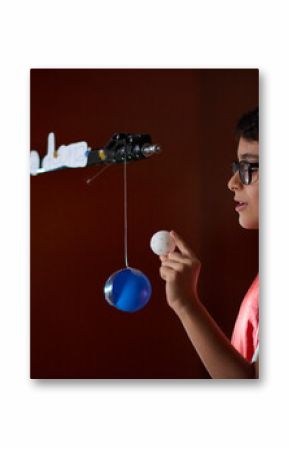 Boy (8-9) making presentation about sun phases at home school during lockdown