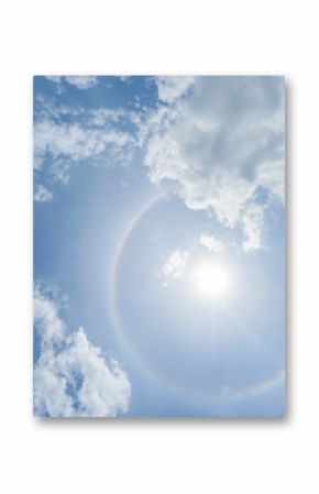 corona of the Sun in bright blue sky with white clouds