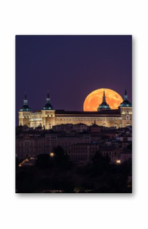 Wonderful scenery of illuminated ancient palace built over town in colorful night with full red Moon in Toledo