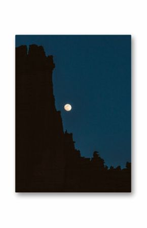 moon rises over the bizarre rock formations of the fisher towers