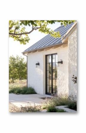 Elegant modern farmhouse with a spacious entrance and lush landscaping in a tranquil countryside setting during late afternoon