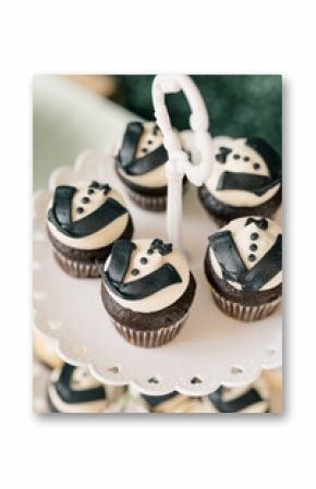 Chocolate cupcakes decorated with tuxedo-style icing on stand