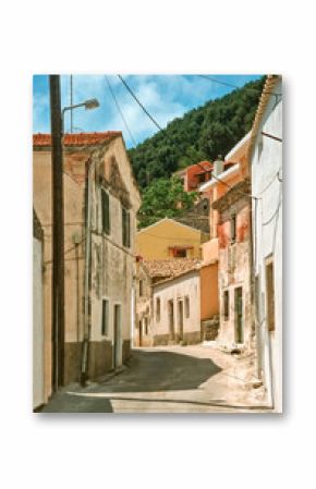Eingescanntes historisches Farbfoto einer menschenleeren, engen Gasse im Ortskern eines alten Dorfes auf der griechischen Insel Korfu in der Mittagssonne