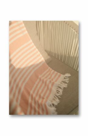 Striped beach towel draped over chair in warm sunlight