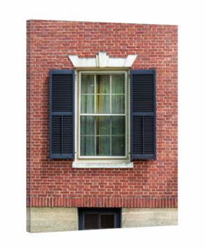 Historic red brick wall featuring decorative lintel and stone foundation window in Boston, Massachusetts, USA 