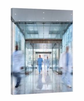 Modern healthcare facility entrance with floor to ceiling glass architecture and medical professionals in motion blur rushing through automatic transparent doors at urban hospital.