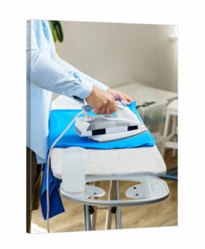 Ironing clothes at home in a cozy living space during daytime