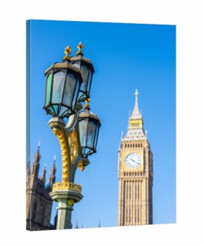Big Ben stands majestically against a clear blue sky, while an ornate lamppost adorned with gold details highlights the vibrant architecture of London.