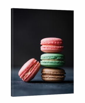 Close up of assorted macaron cookies on black background.
