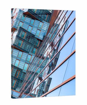 Modern building glass facade reflecting clear blue sky
