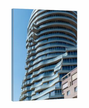 Modernes gläsernes Hochhaus mit geschwungenen Balkonen im Sonnenlicht, Tirana, Albanien