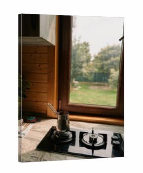 Cozy kitchen scene with a gas stove and kettle on simmer, warm natural light from a window, creating a calm and inviting home atmosphere cozy vibe