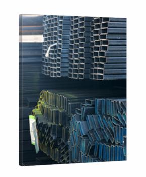 Close-up of stacked square steel hollow section profiles with clean cut edges stored inside an industrial metal warehouse