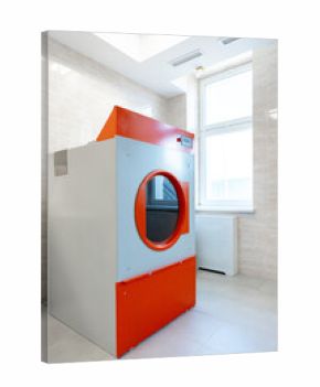 Modern laundry room featuring a large industrial washer with orange and gray design in a well-lit environment