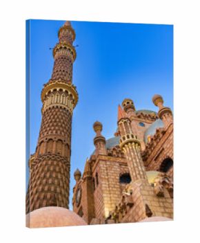Beautiful architecture of a mosque with intricate details and a towering minaret against a clear blue sky