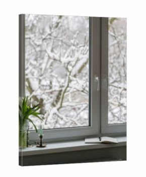 View of snow-covered trees from a cozy indoor space during winter season