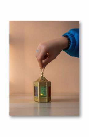 human hand holding A Ramadan lantern with colorful glass panels