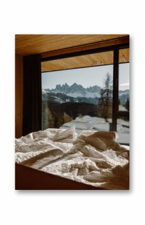 A modern wooden chalet living space bathed in natural light, with expansive windows showcasing a snowy mountain landscape. A perfect blend of warmth, elegance, and nature.
